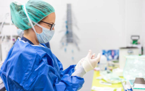 Covid-19. Female nurse puts on protective gloves. Personal protective equipment in the fight against Coronavirus disease.